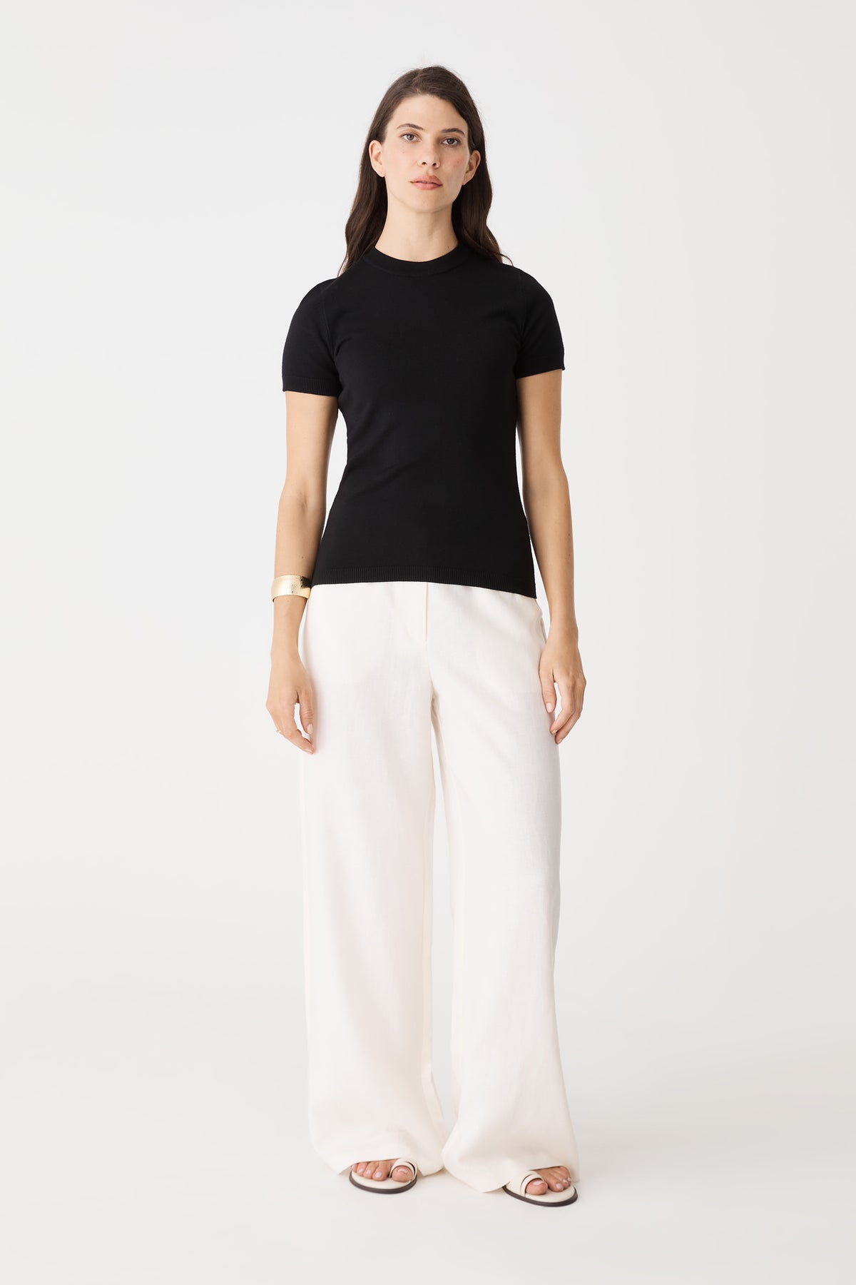 Catherine Short Sleeve Knit in black, front view worn with white wide-leg pants