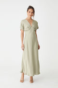 Catalina V-Neck Satin Dress in sage, front view with batwing sleeves and bias-cut midi skirt, worn with heels