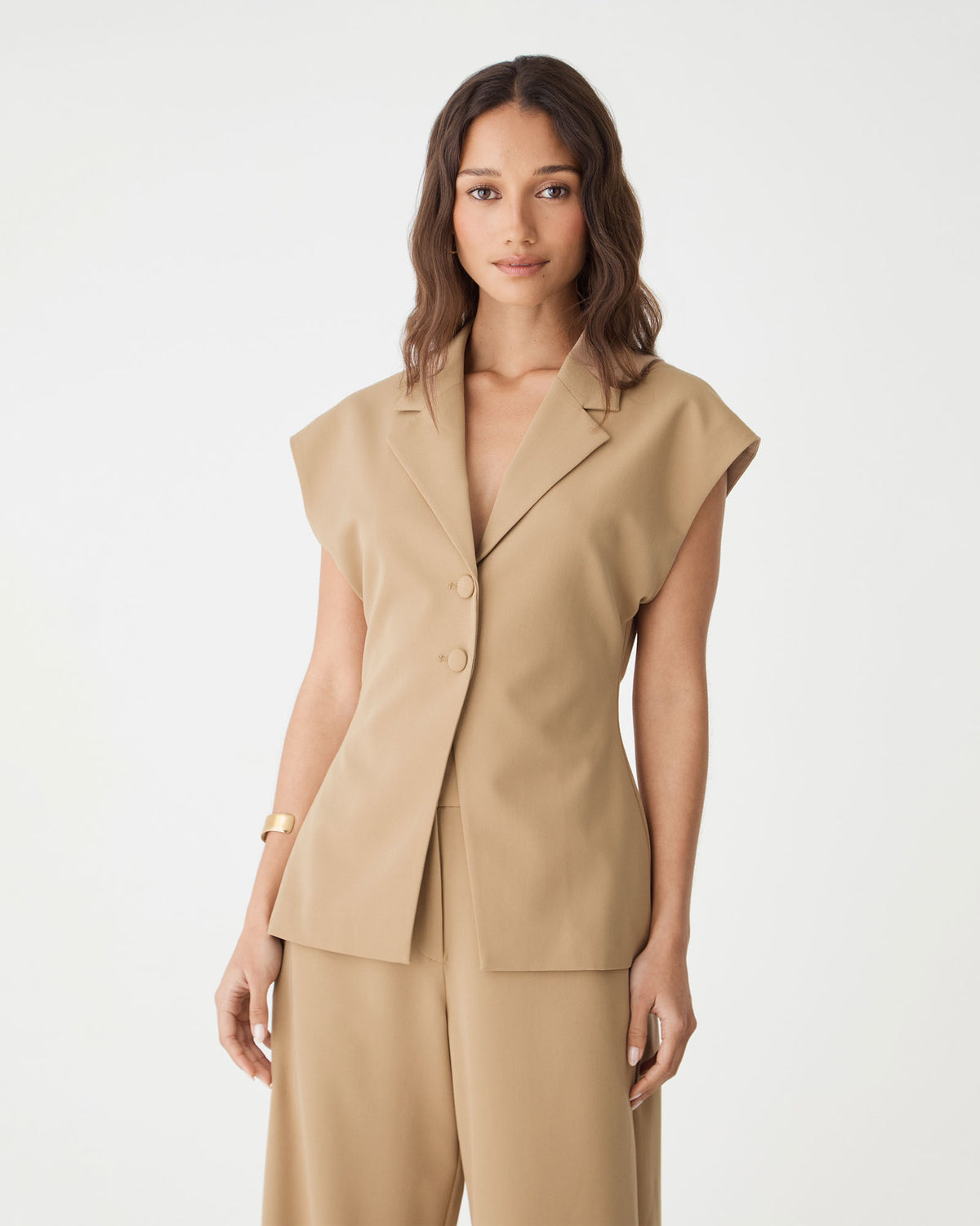 Close-up front view of the camel blazer showing deep V-neckline, notch lapels and cap sleeves