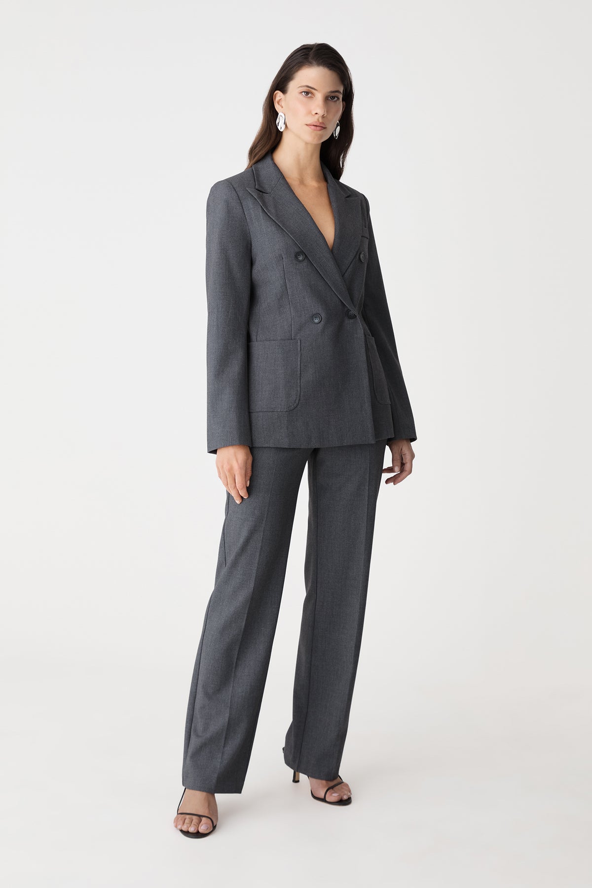 Side-front angle of the dark grey blazer and matching pants