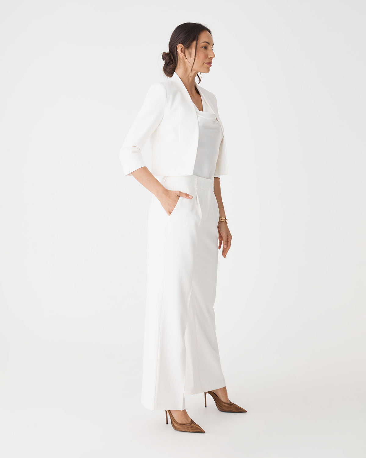 Side view showing the straight wide leg and side pocket of the ivory pants