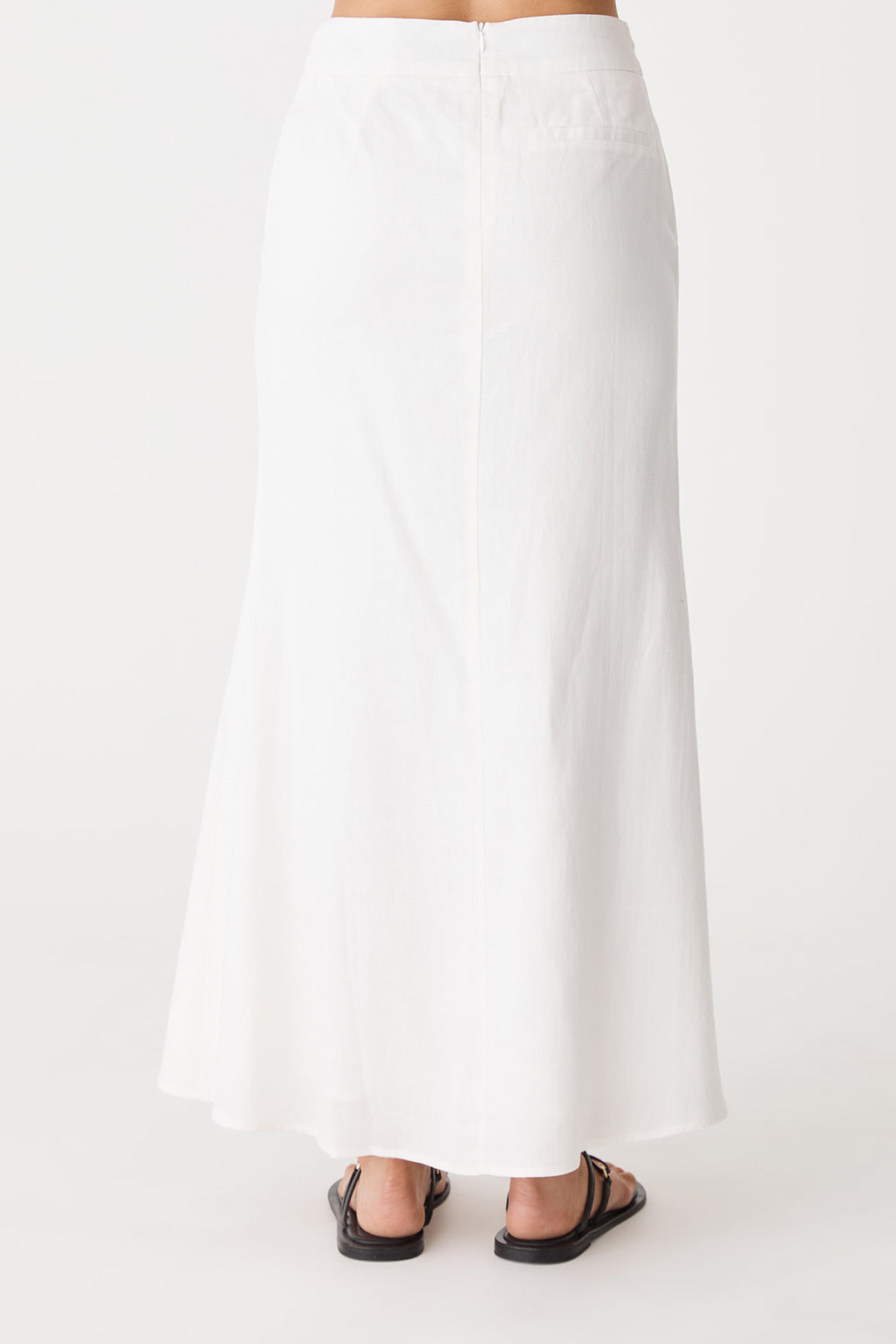 Back view showing the invisible zip and flared hem of the ivory maxi skirt