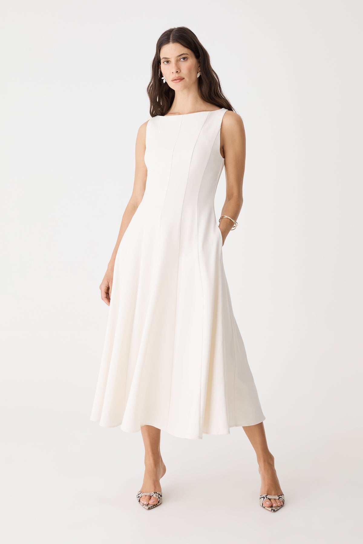 Front view of the cream Sally Panel Midi Dress with hands in side pockets