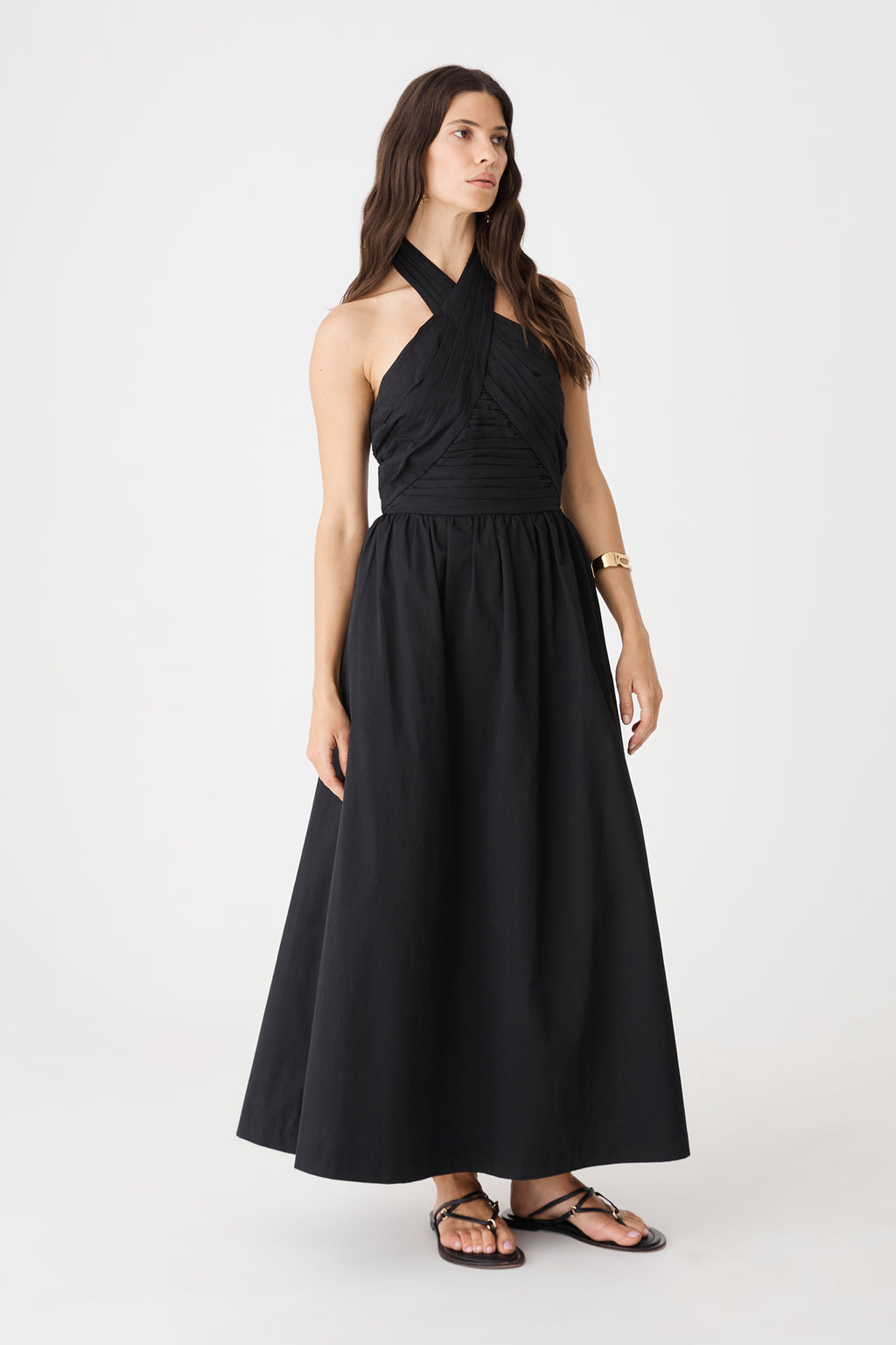 Side view of the black Kayleigh Cotton Halter Dress showing pleated bodice and maxi skirt