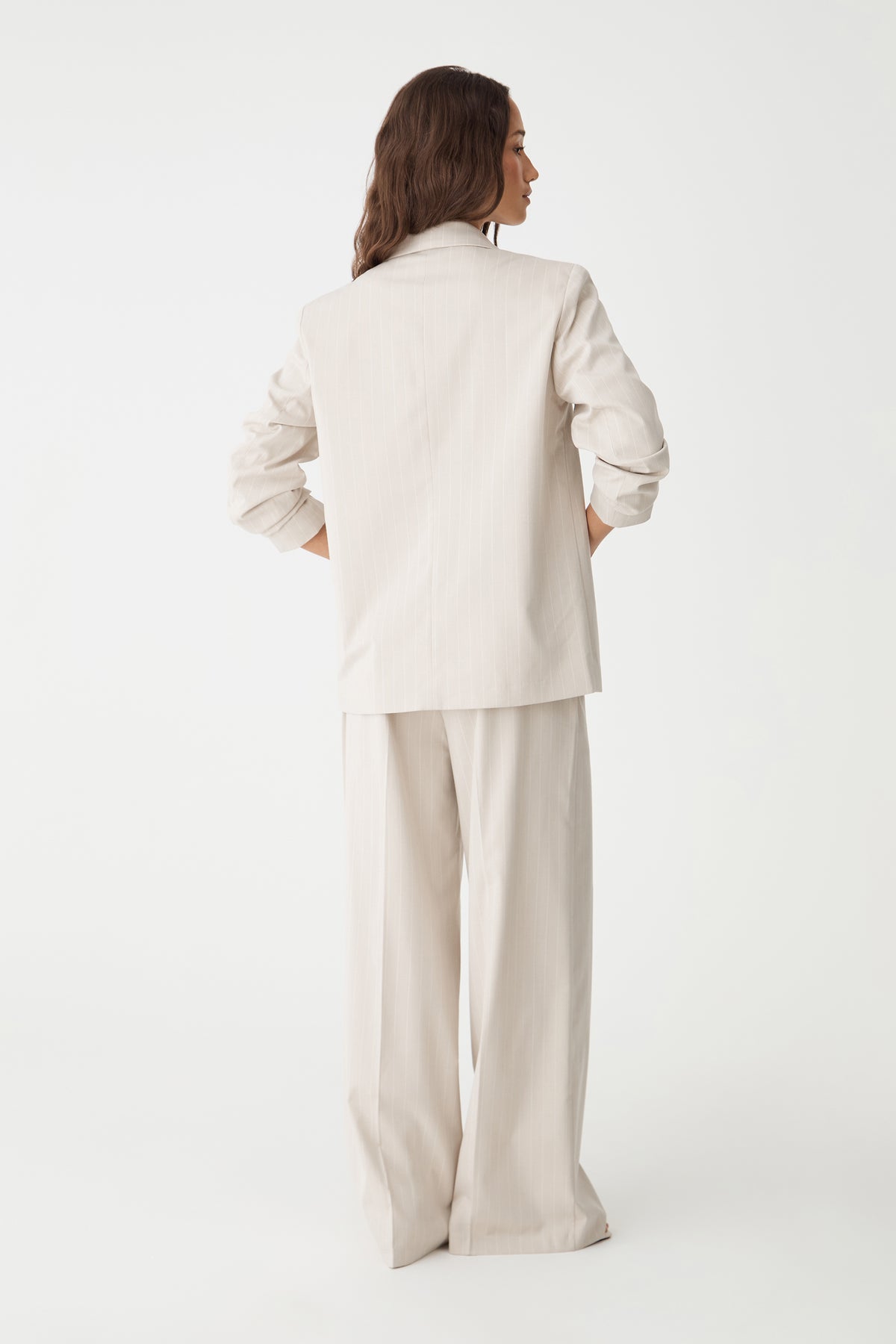 Back view of the beige pinstripe blazer and matching trousers