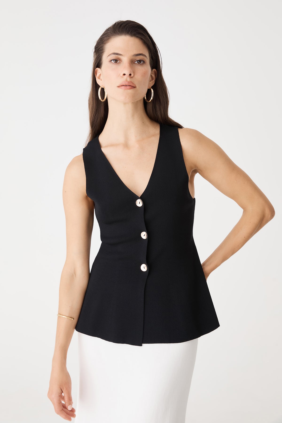 Front view of the black Valerie Button Peplum Knit Top with white skirt
