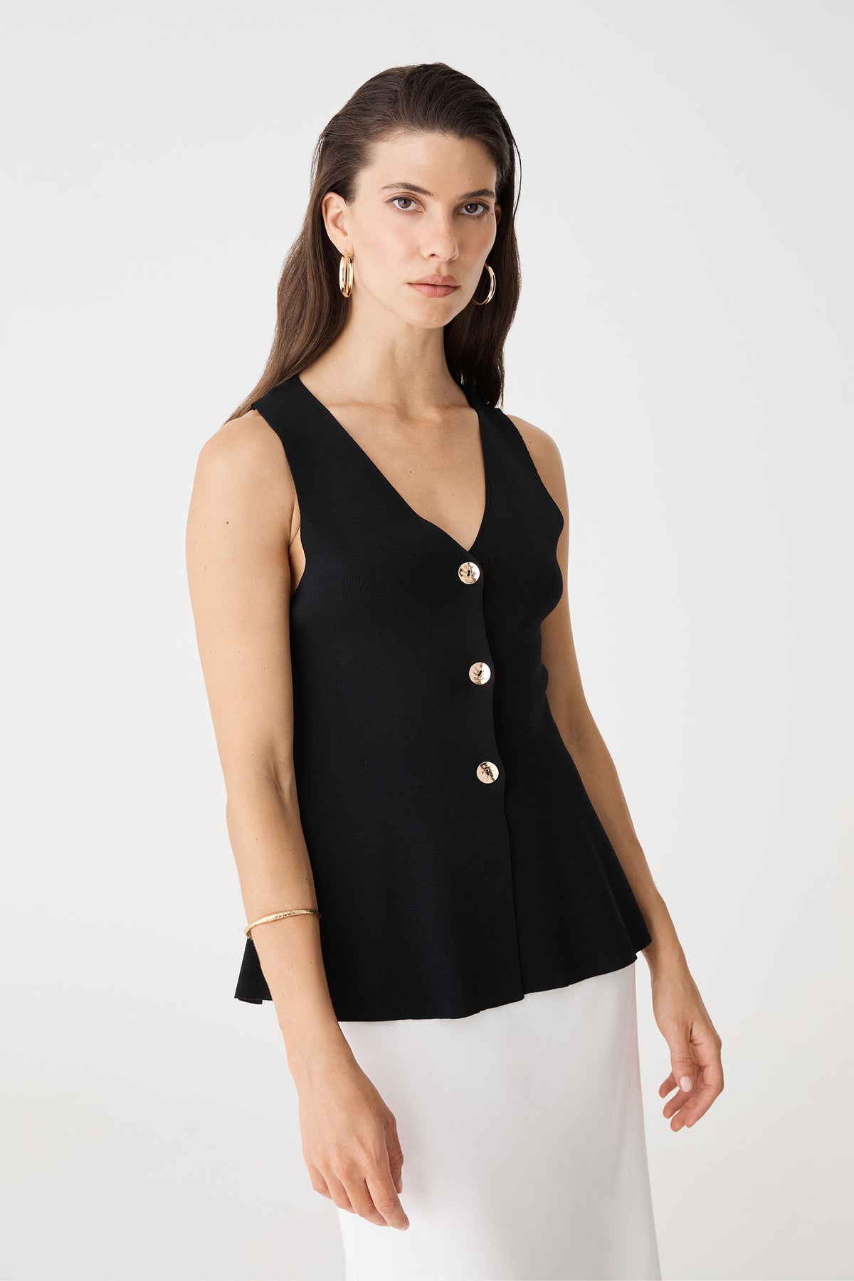 Side view of the black Valerie Button Peplum Knit Top with flared peplum hem