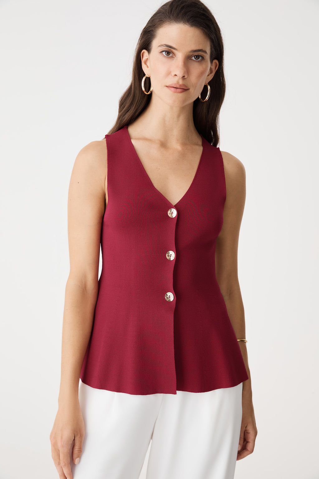 Front close-up of the gold-tone button placket and flared peplum hem