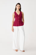 Valerie Button Peplum Knit Top in berry red, front view worn with white wide-leg trousers