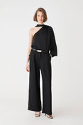 Daphne Pleated Crepe Pants in black, front view, worn with a black one-shoulder top and belt