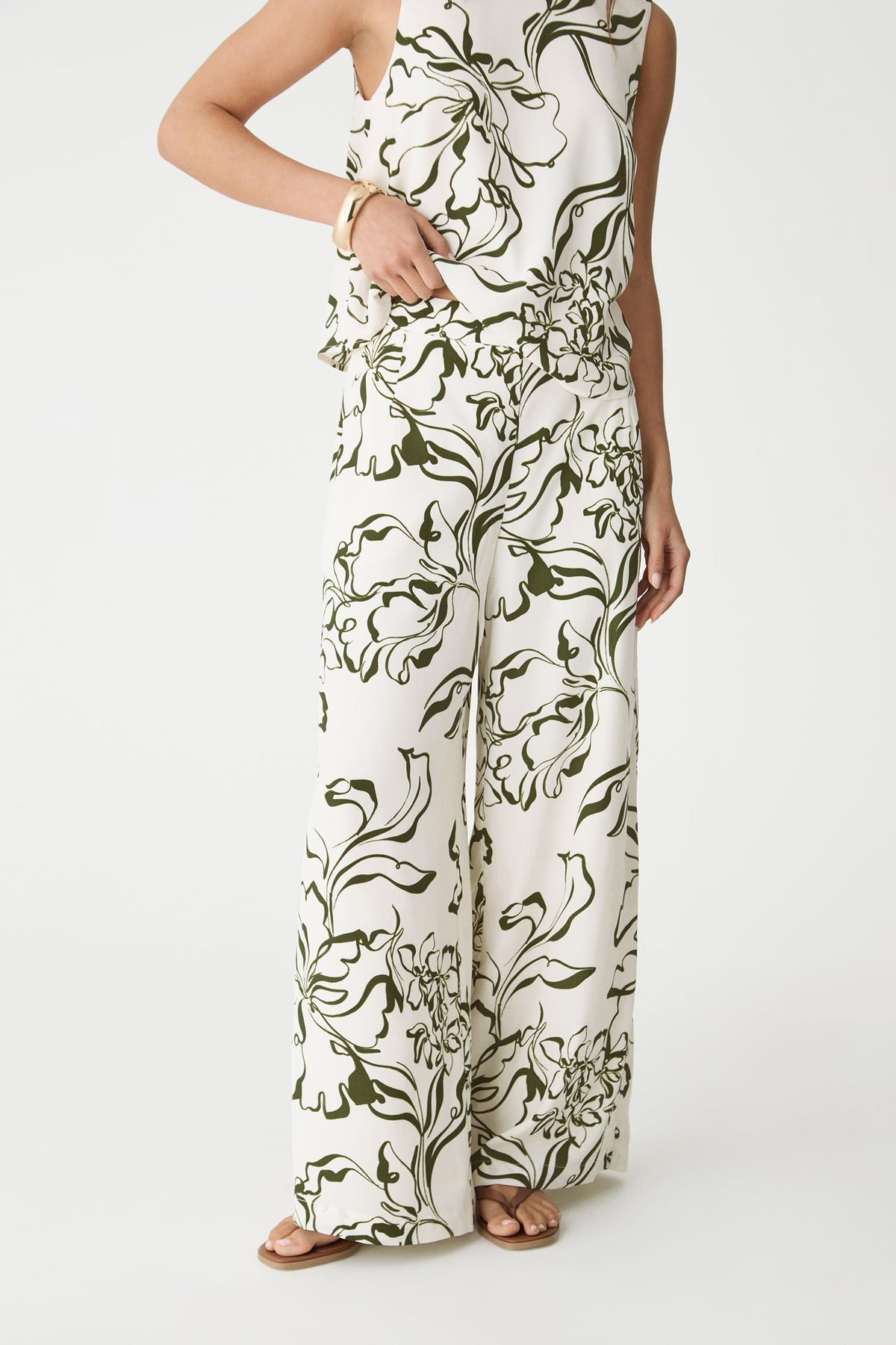 Front view of the cream and olive botanical print wide-leg pants, cropped at the waist