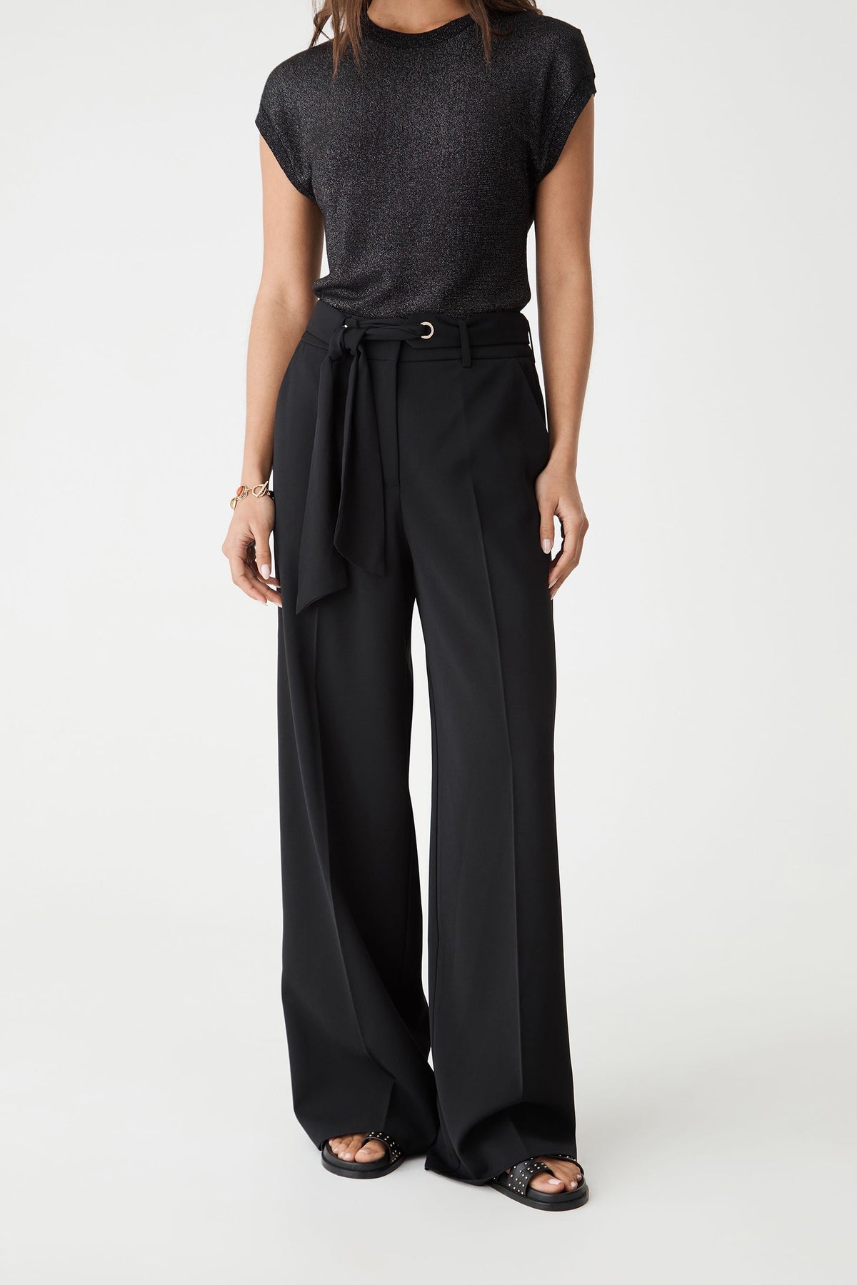 Close-up front view of the black wide leg pants showing the tied scarf belt and side pockets
