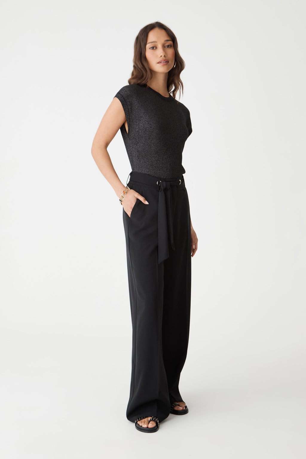 Side view of the black wide leg pants with belt tied at the waist