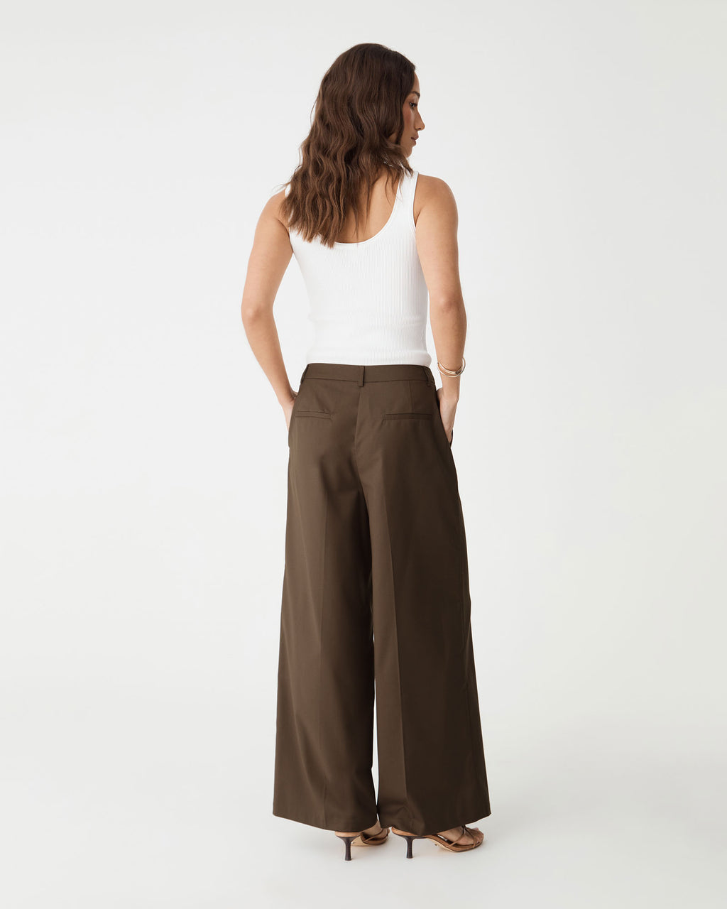 Back view showing faux welt pockets and waist darts on the cocoa brown wide leg pants