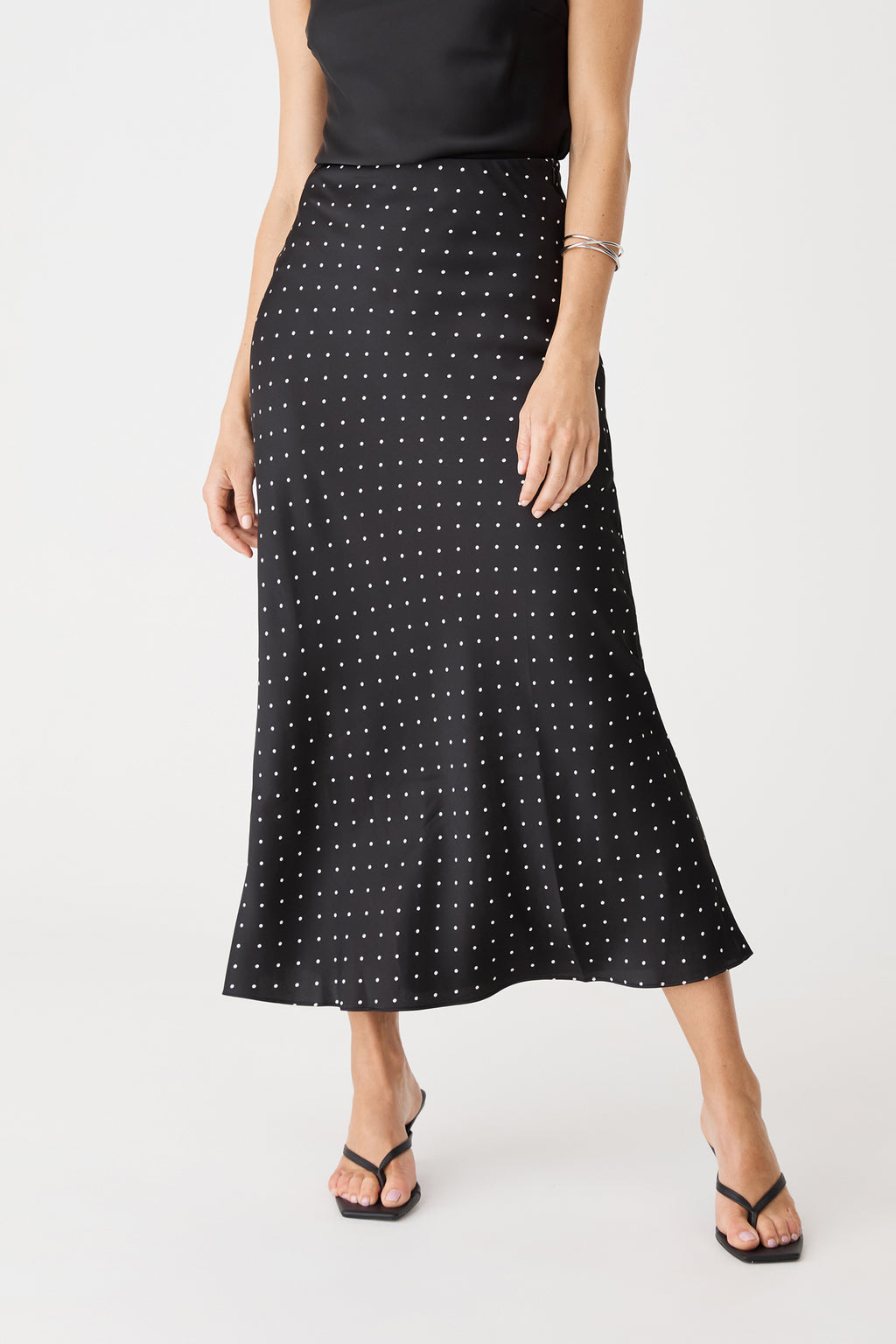 Close-up of the polka dot skirt front, showing high-rise waistband and midi length