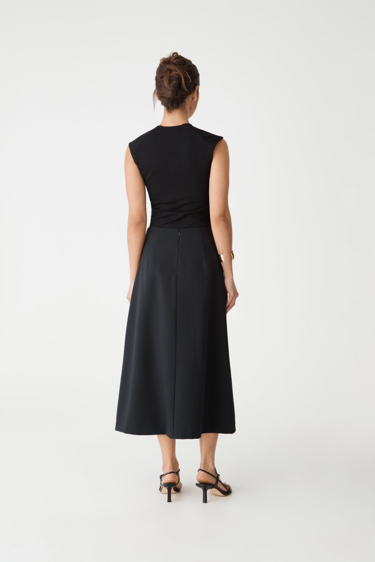 Back view showing waist darts and invisible back zip of the black midi skirt