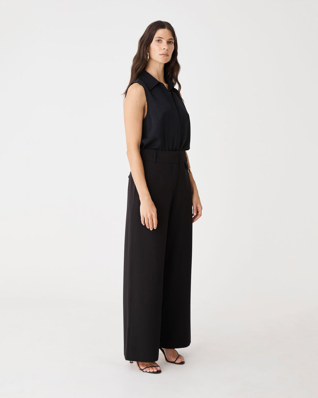 Side view of the black Brooklyn Sleeveless Shirt with black wide-leg trousers