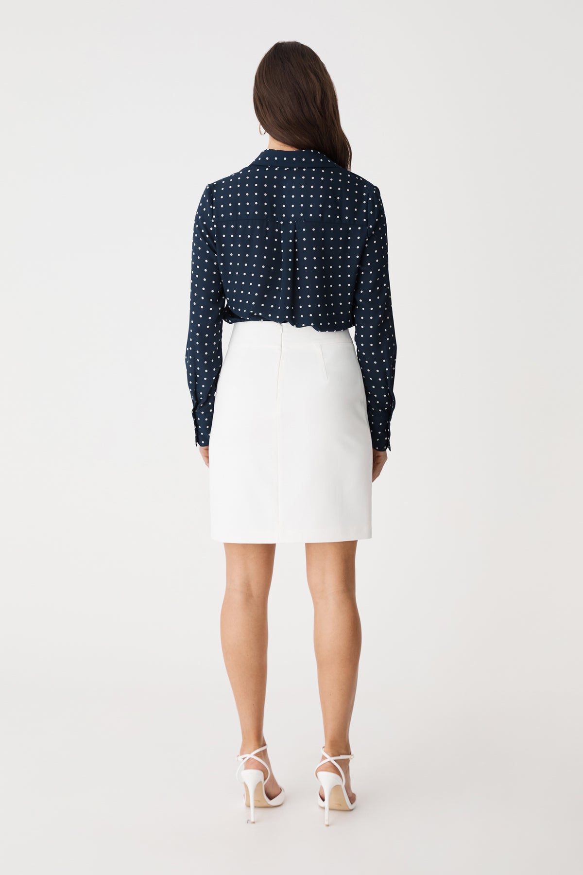 Back view of the Danielle Spot Shirt in Navy Spot with a white skirt
