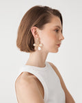 Zaria Bloom Drop Earrings in beige raffia with gold-tone edging, worn, side view