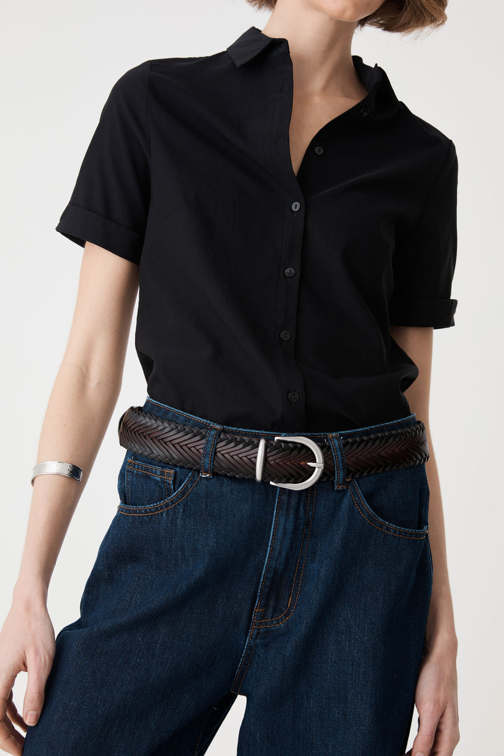 Close-up of the woven espresso belt showing chevron weave and silver-tone horseshoe buckle