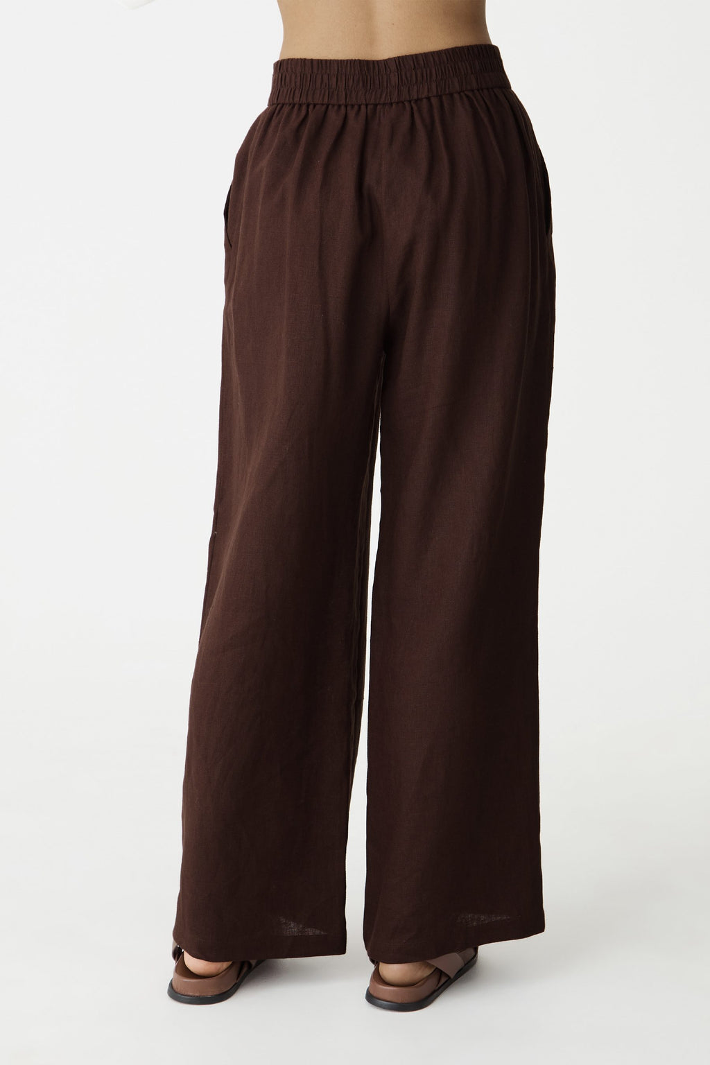 Close-up of the high-rise waistband, side pockets and wide legs in dark chocolate